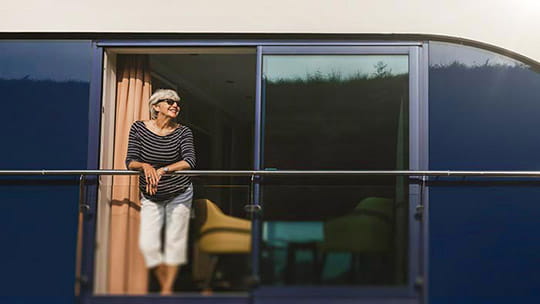 A woman enjoying the view from her French Balcony on Spirit of the Rhine